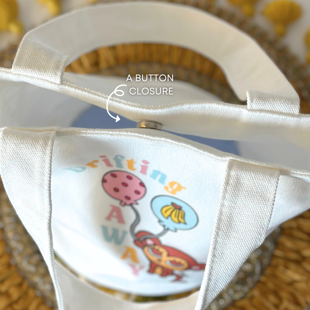 Close-up of a button closure on a bag with a monkey and balloons design.